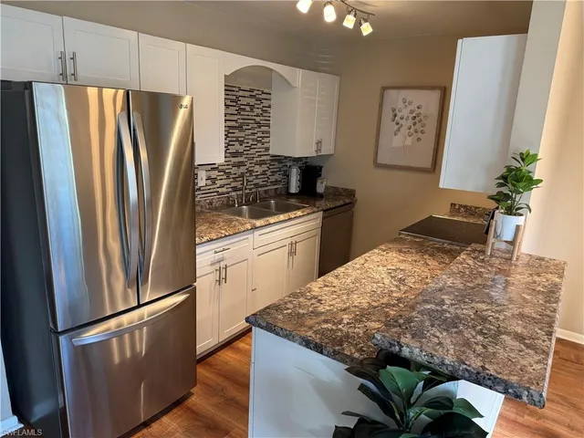 a kitchen with stainless steel appliances granite countertop a refrigerator and a stove