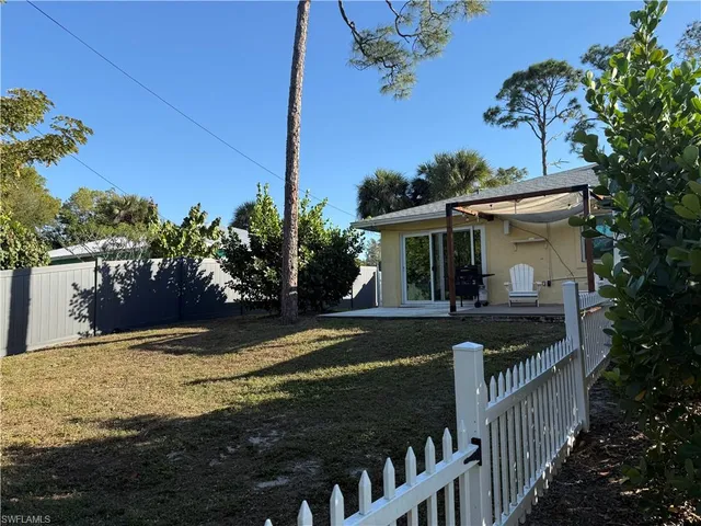 a view of a house with backyard and a tree