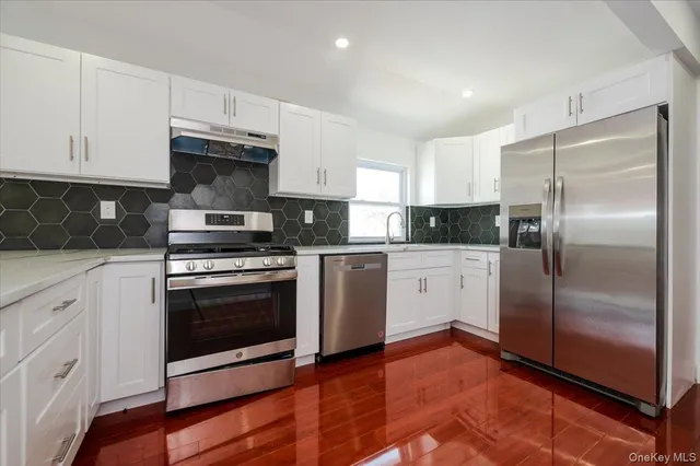 a kitchen with cabinets stainless steel appliances and wooden floor