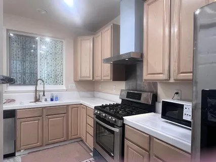 a kitchen with cabinets appliances a sink and a window