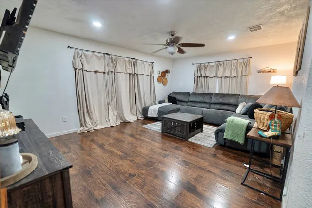 a living room with furniture and a wooden floor