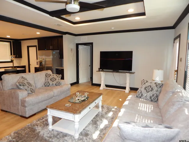 a living room with stainless steel appliances kitchen island granite countertop furniture and a large window