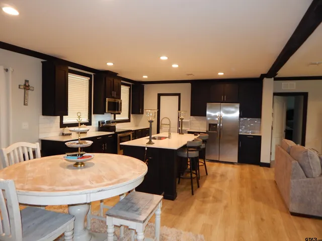 a bathroom with a granite countertop bathtub shower sink vanity and toilet