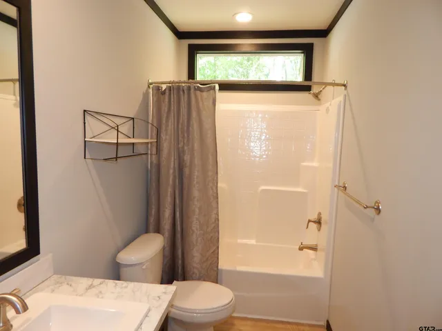 a bedroom with a bed and a lamp on dresser