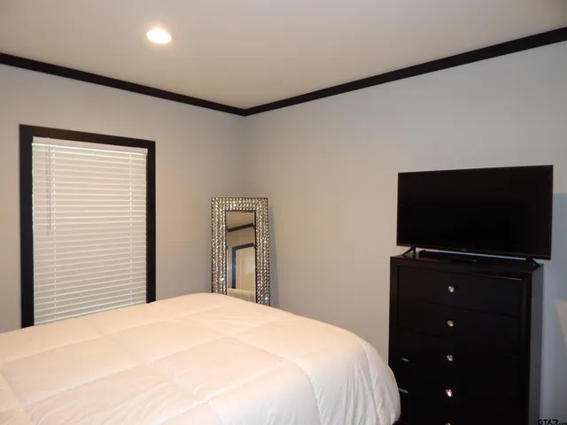 a bedroom with a bed and a flat screen tv