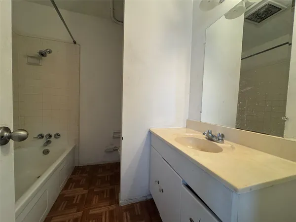 a bathroom with a granite countertop sink and a shower