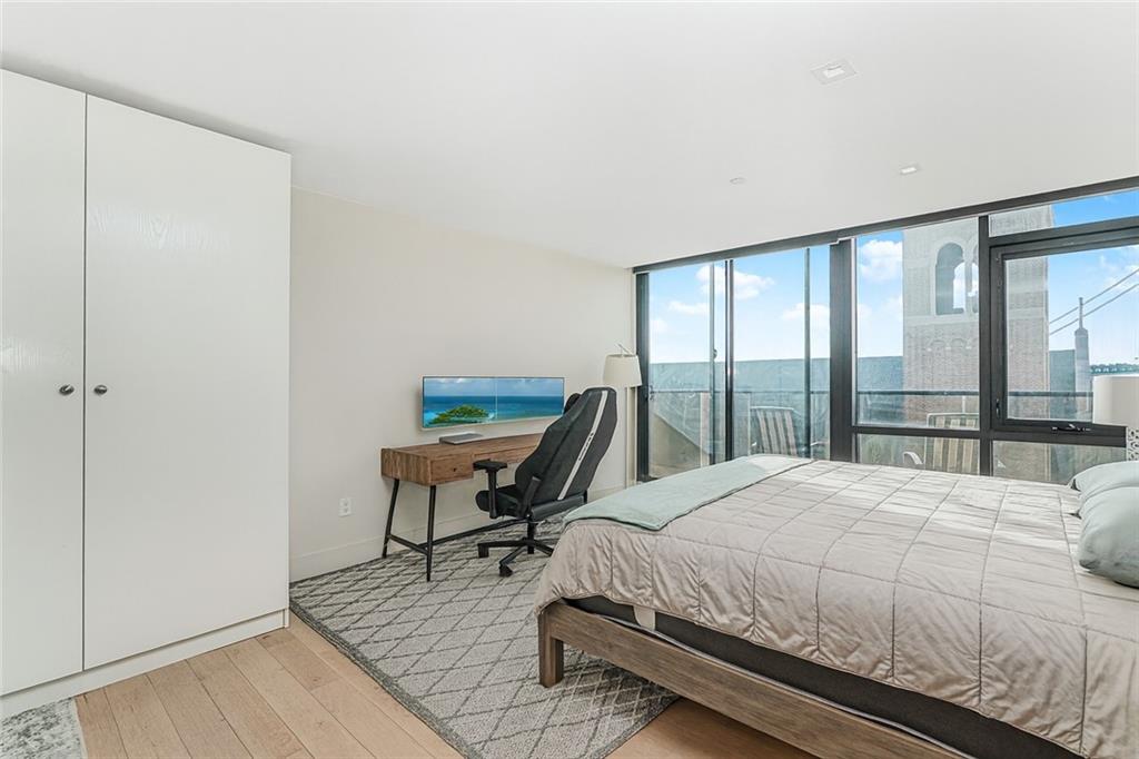 401 95th Street, Unit 6A Brooklyn, NY 11209 - Photo 12 of 24 a bedroom with a bed a table and a large window