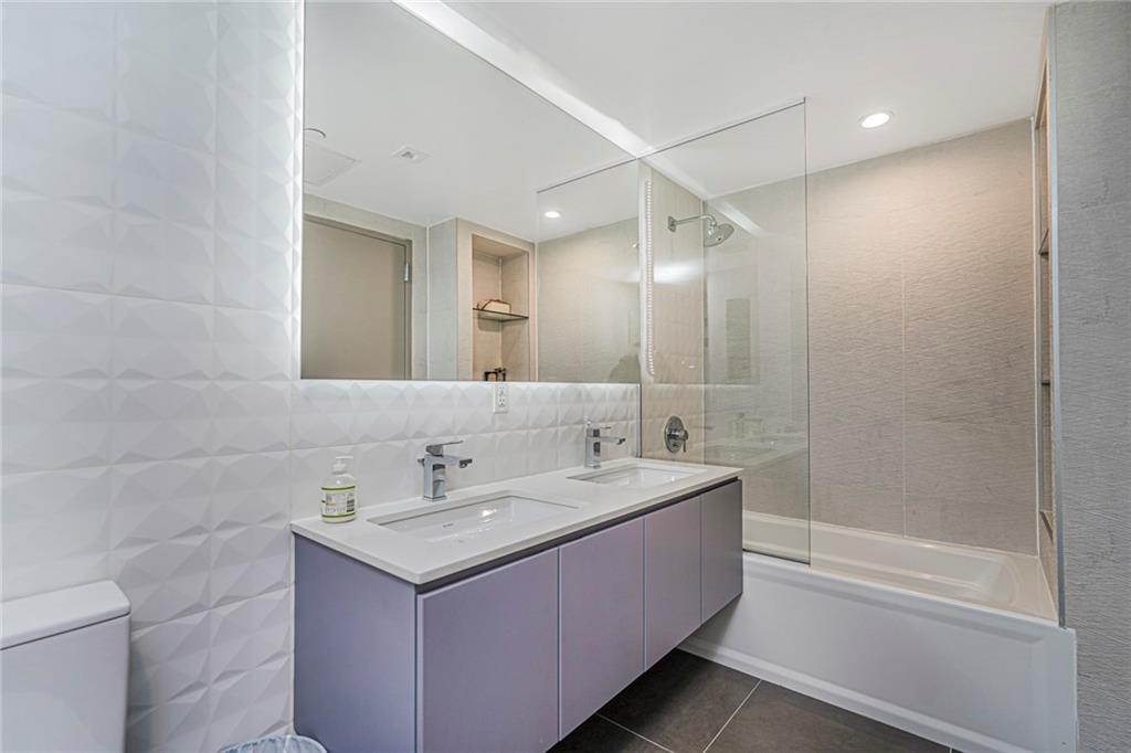 401 95th Street, Unit 6A Brooklyn, NY 11209 - Photo 16 of 24 a bathroom with a sink a toilet and shower