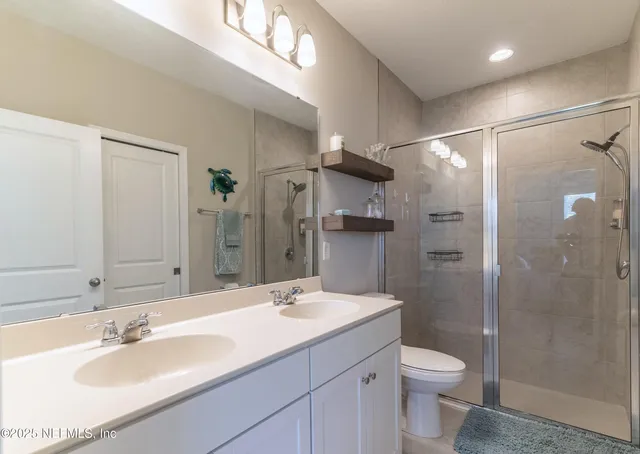 a bathroom with a sink toilet a mirror and shower