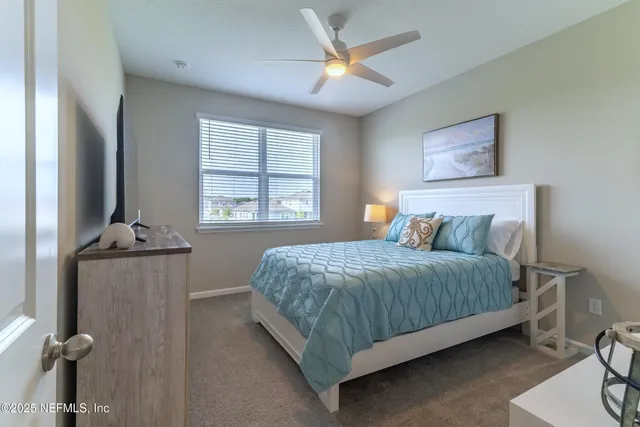 a bedroom with a bed mirror and a window