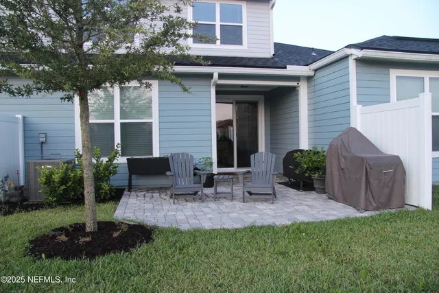 a view of backyard of house with outdoor seating and green space