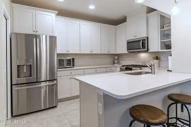 a kitchen with stainless steel appliances a refrigerator sink and microwave