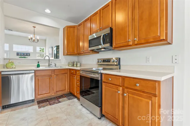 a kitchen with stainless steel appliances granite countertop a sink stove and microwave