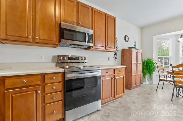 a kitchen with stainless steel appliances granite countertop a stove a sink and a microwave