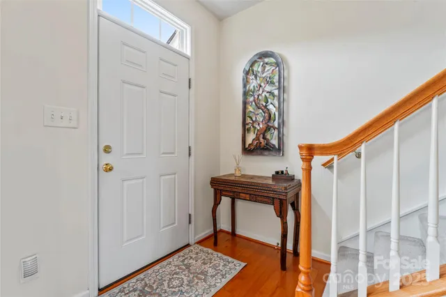 a view of a hallway with wooden floor and a entryway