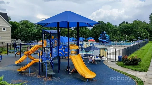 a view of a park with a slide and potted plants
