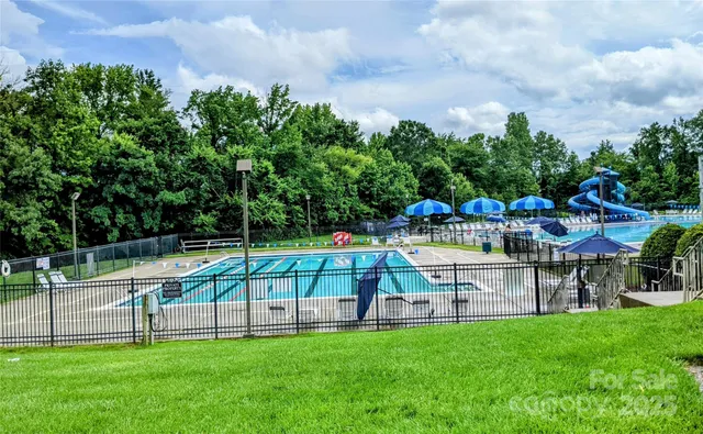 a view of yard with swimming pool and bench