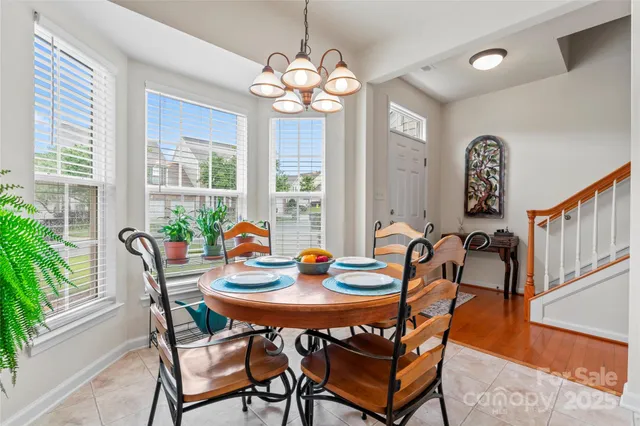 a dining room with furniture a large window and wooden floor