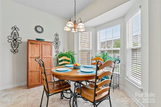 a dining room filled chandelier and wooden floor