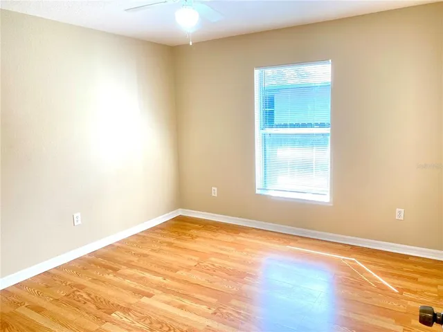 an empty room with wooden floor and a window
