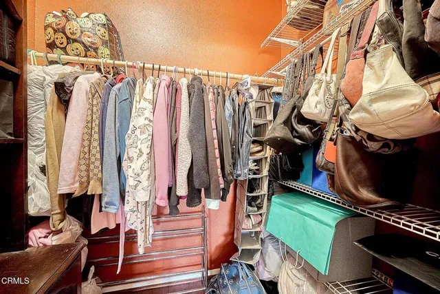 a view of walk in closet with clothes and shoes