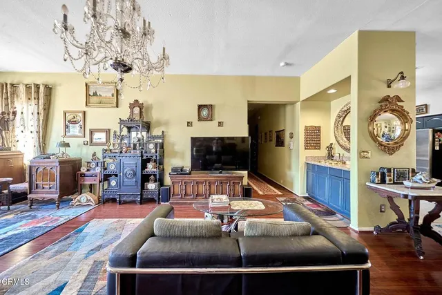 a living room with furniture a flat screen tv and a clock