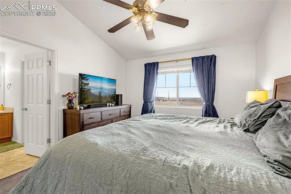 a bedroom with a bed and a flat tv screen on dresser