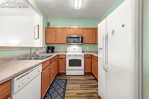a kitchen with a white stove top oven and sink