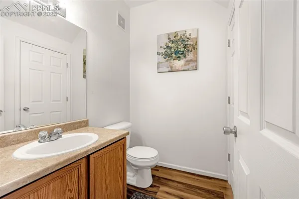a bathroom with a granite countertop sink toilet and a mirror