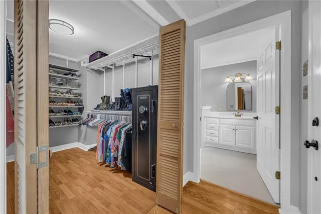 a view of walk in closet with clothes and shoes