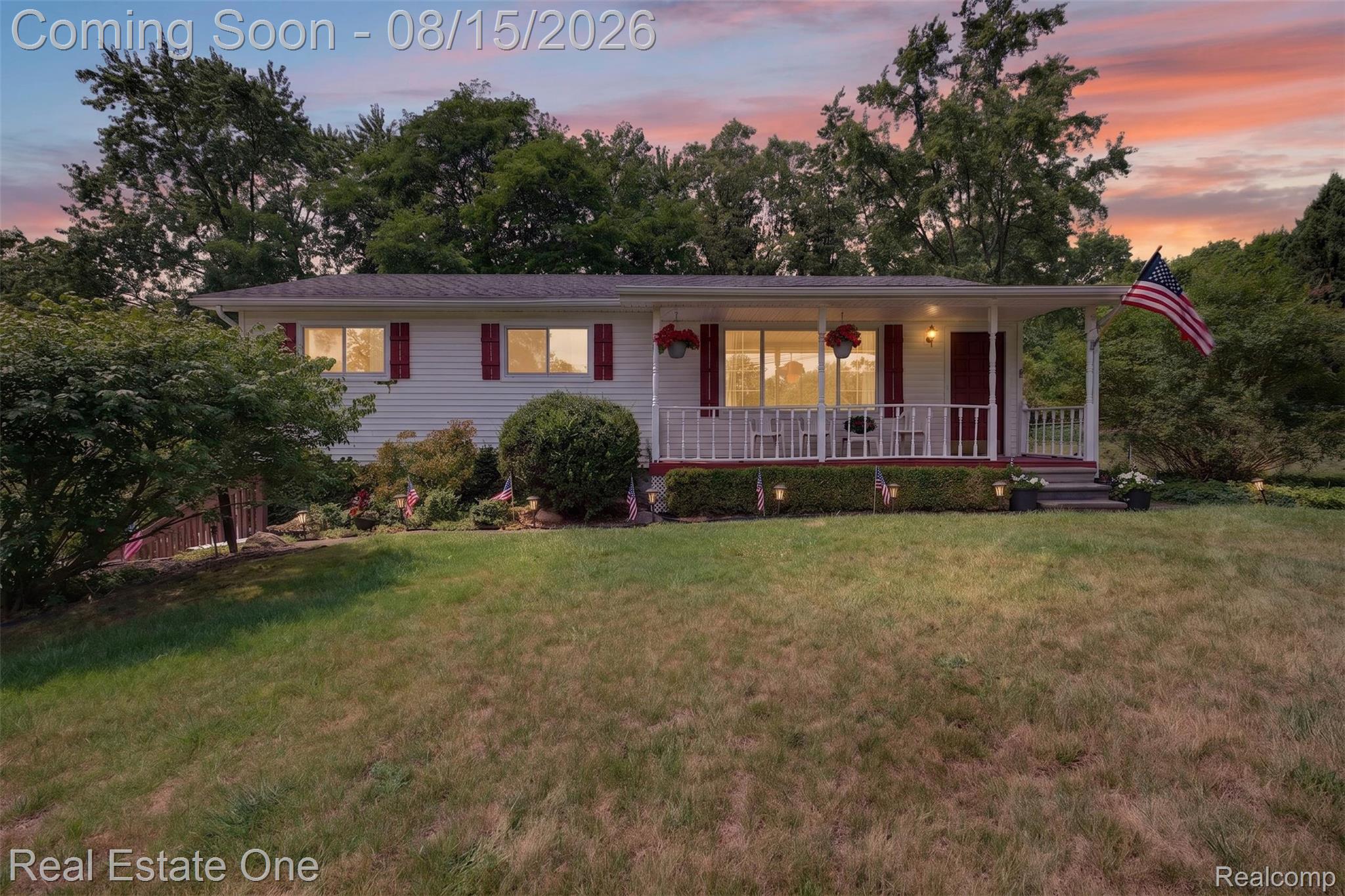 454 South Baldwin Road Oxford, MI 48371 - Photo 50 of 64 White siding exterior with red shutters, covered front porch, white porch railing, and a sloped front lawn