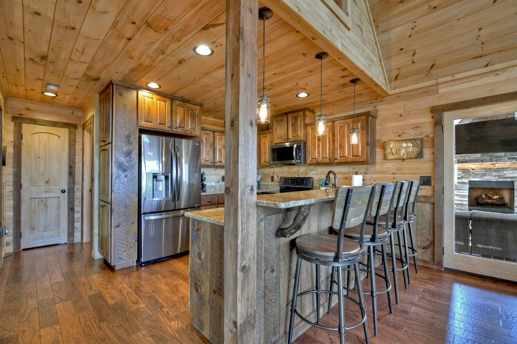 136 Oasis Drive Blue Ridge, GA 30513 - Photo 17 of 47 a kitchen with stainless steel appliances kitchen island granite countertop a refrigerator a stove top oven and sink with wooden floor