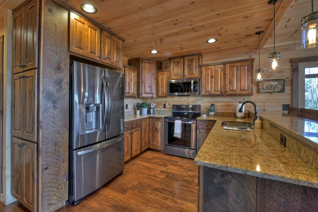 136 Oasis Drive Blue Ridge, GA 30513 - Photo 18 of 47 a kitchen with stainless steel appliances granite countertop a refrigerator a stove top oven a sink and dishwasher