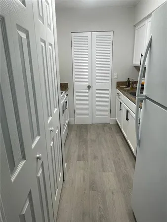 a kitchen with white cabinets and white stainless steel appliances