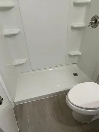 a white toilet sitting next to a bath tub