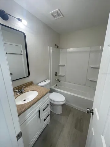 a bathroom with a granite countertop toilet a sink and bathtub