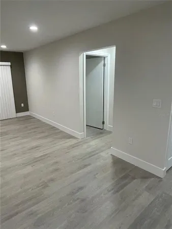 an empty room with wooden floor and closet