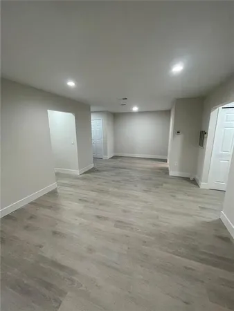 an empty room with wooden floor and window