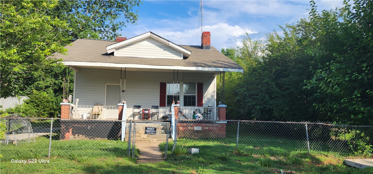 105 Hope Avenue Seneca, SC 29678 - Photo 2 of 33 A classic front porch home with a chain link fence, offering a welcoming facade.