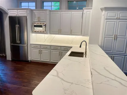 a kitchen with granite countertop a refrigerator and a sink