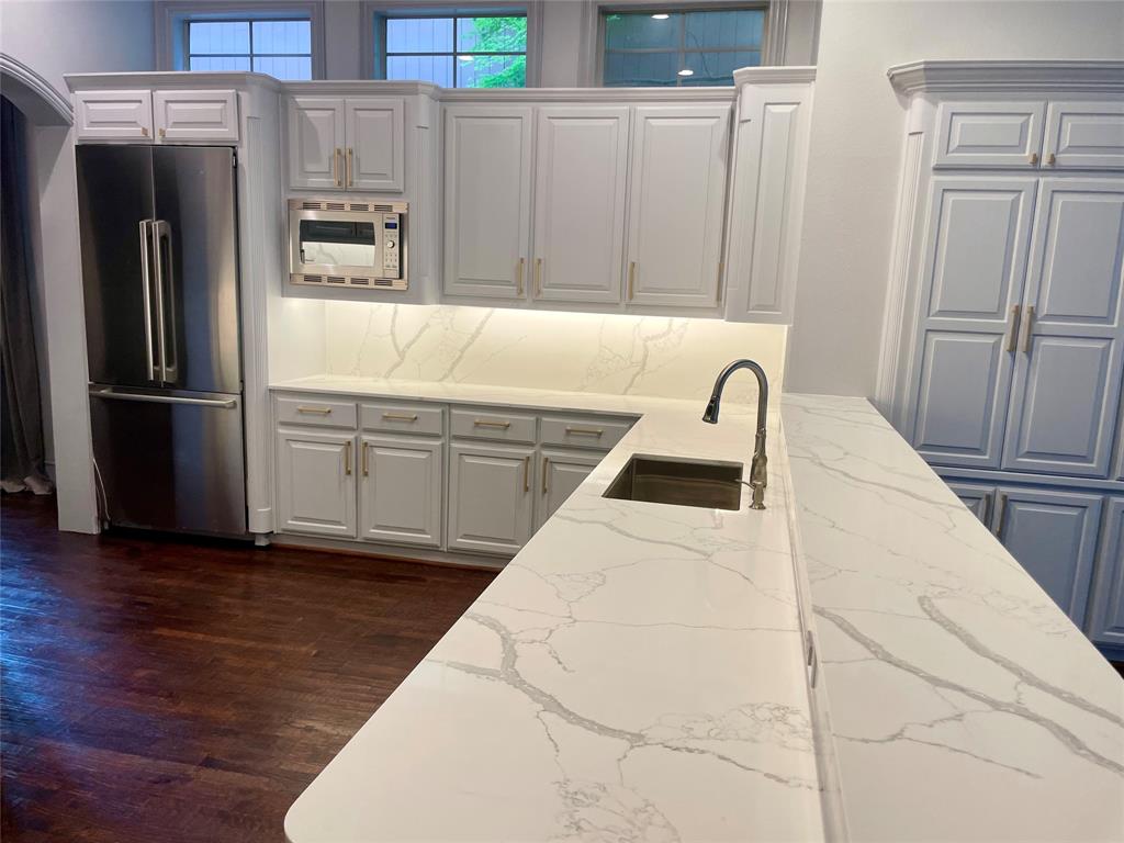 4139 Herschel Avenue Dallas, TX 75219 - Photo 13 of 30 a kitchen with granite countertop a refrigerator and a sink