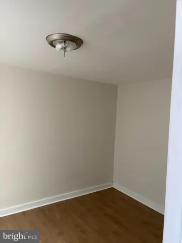 an empty room with a ceiling fan and wooden floor