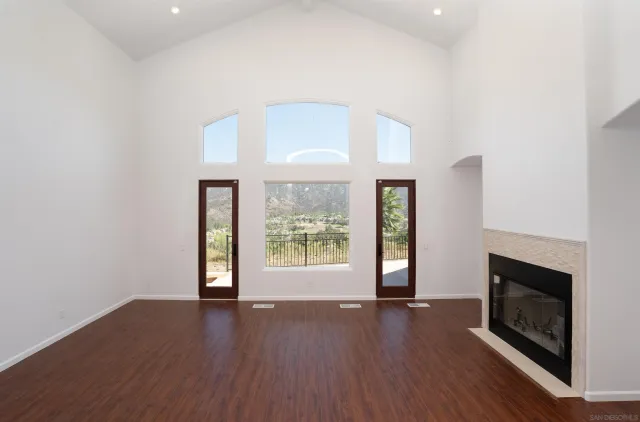 a view of a livingroom with furniture a flat screen tv and wooden floor