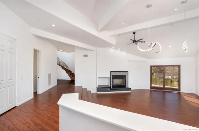 a kitchen with stainless steel appliances kitchen island granite countertop a dining table chairs and white cabinets