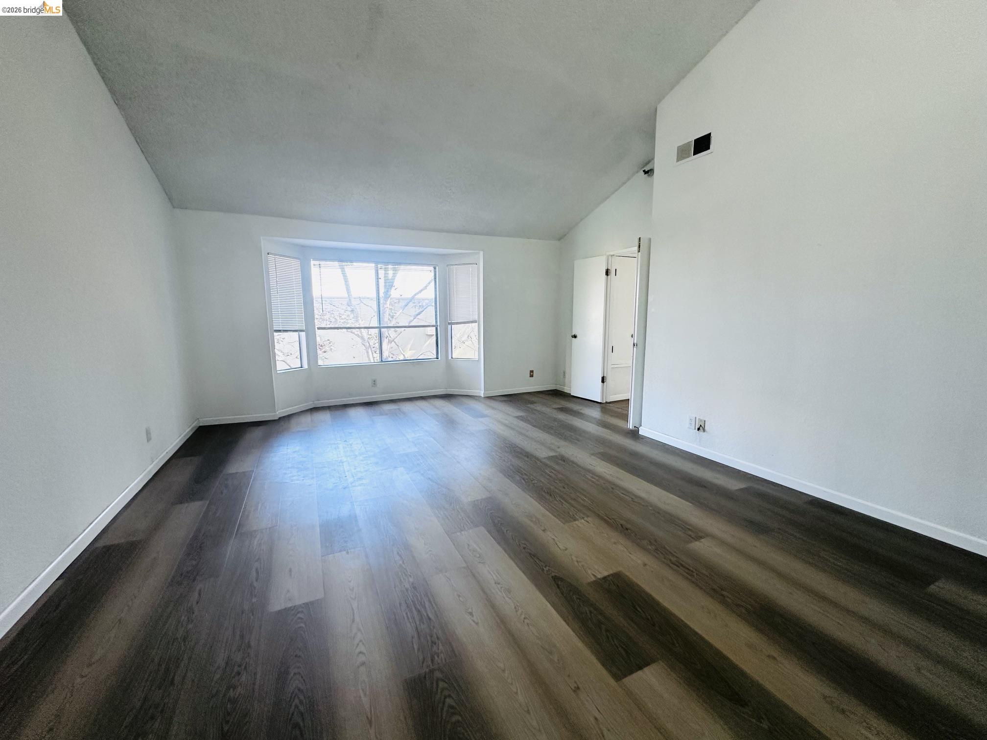 2121 Vale Road, Unit 50 San Pablo, CA 94806 - Photo 21 of 26 Vaulted ceiling, wood-finish flooring, bay window, white walls, and white trim