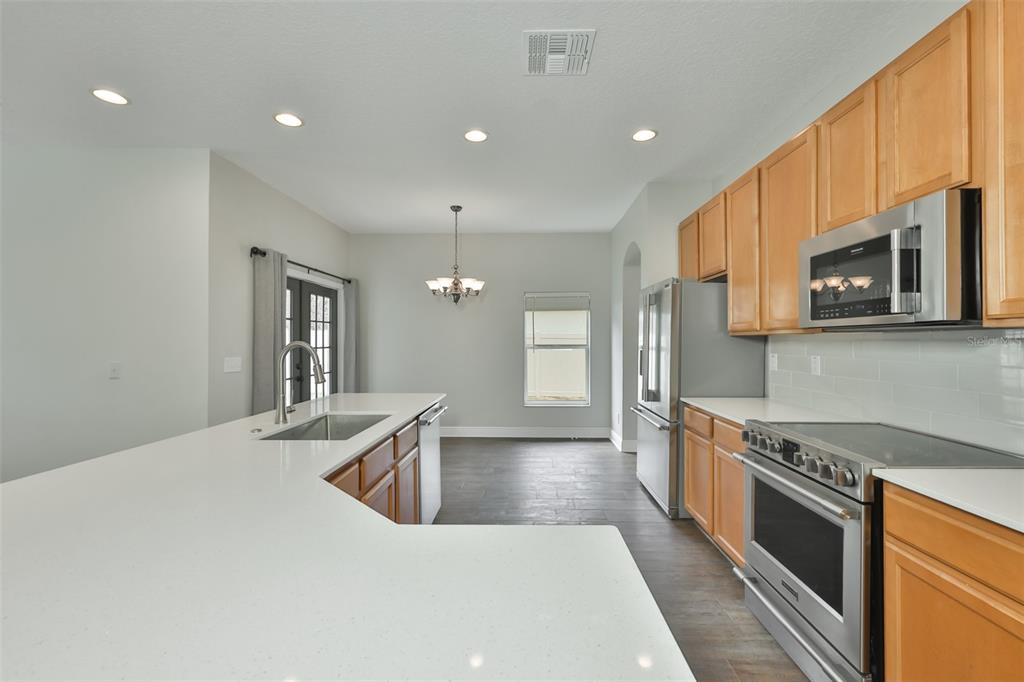 708 Coade Stone Drive Seffner, FL 33584 - Photo 12 of 48 a kitchen with stainless steel appliances granite countertop a sink stove and refrigerator