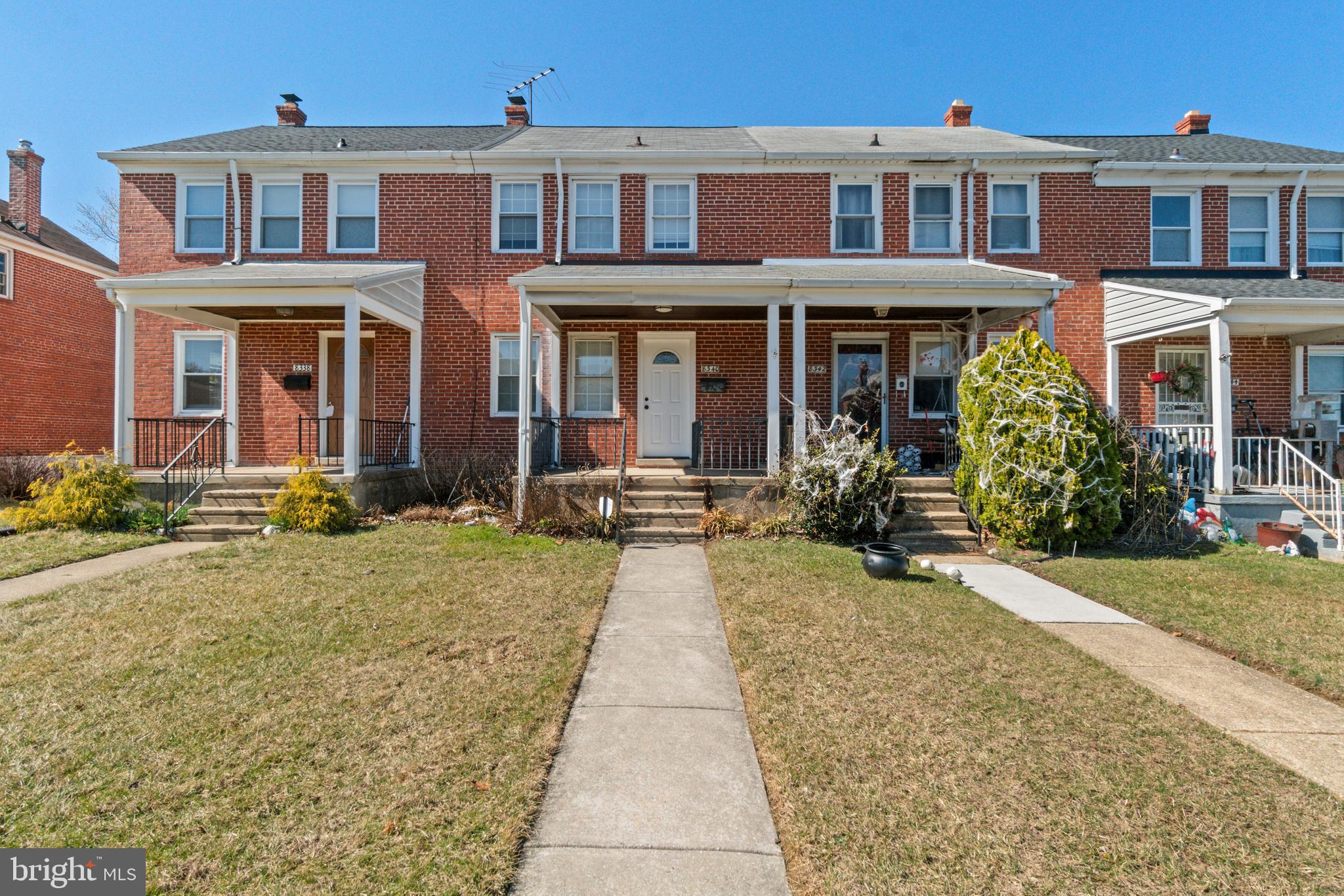 front view of a brick house with a small yard