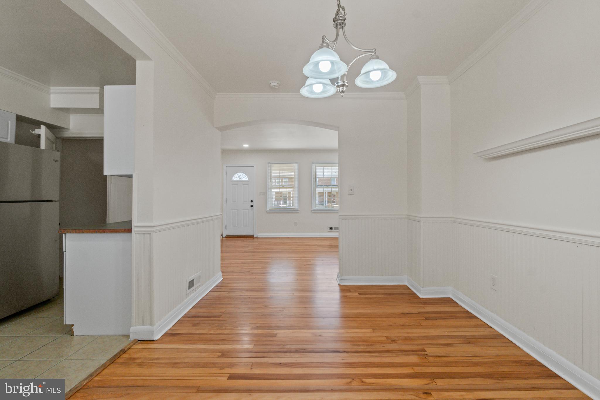 8340 Edgedale Road Baltimore, MD 21234 - Photo 11 of 33 a view of a hallway with wooden floor and a kitchen