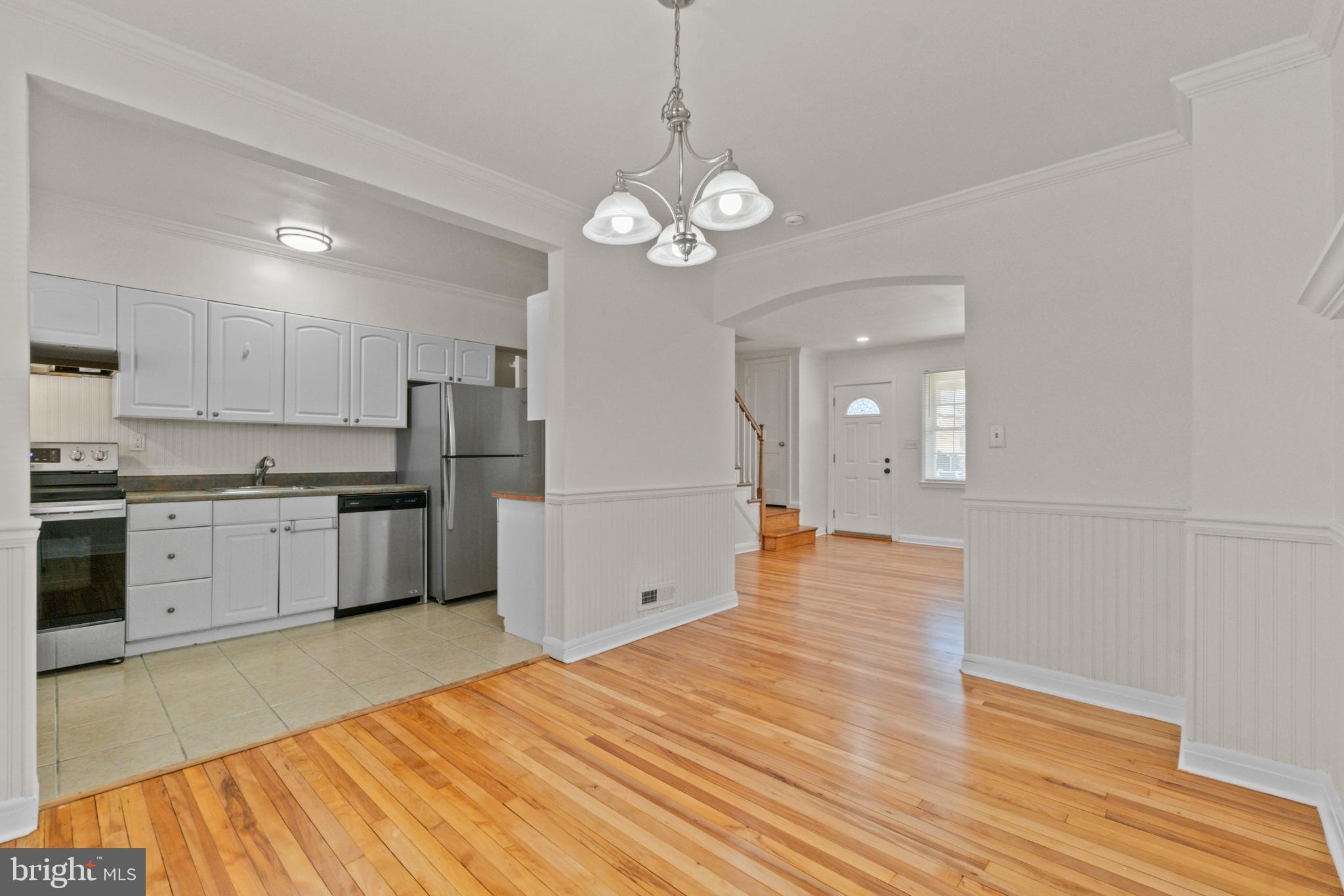 8340 Edgedale Road Baltimore, MD 21234 - Photo 10 of 33 a open kitchen with stainless steel appliances granite countertop a sink dishwasher a refrigerator and white cabinets with wooden floor