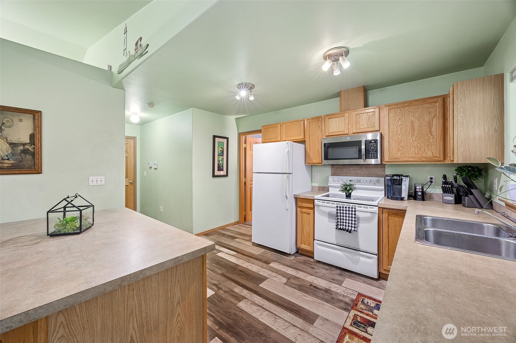 7510 191st Avenue Southwest Rochester, WA 98579 - Photo 18 of 28 a kitchen with refrigerator cabinets and wooden floor